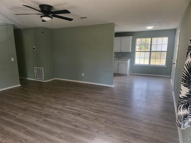 unfurnished living room with a textured ceiling, ceiling fan, and hardwood / wood-style flooring