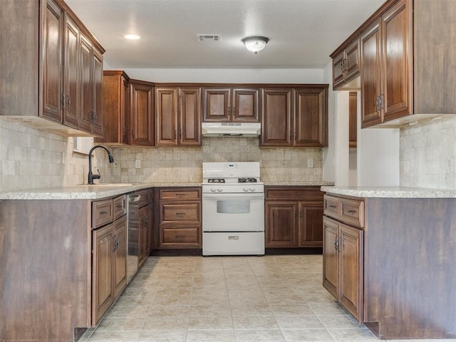 kitchen featuring backsplash, white range with gas stovetop, and sink