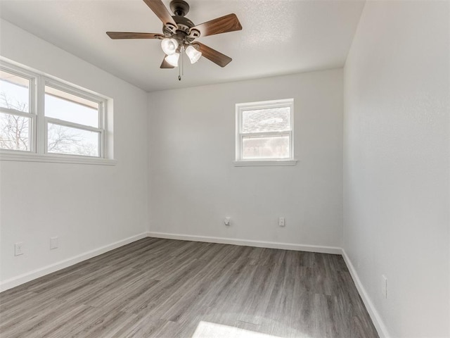 unfurnished room with ceiling fan and dark hardwood / wood-style flooring