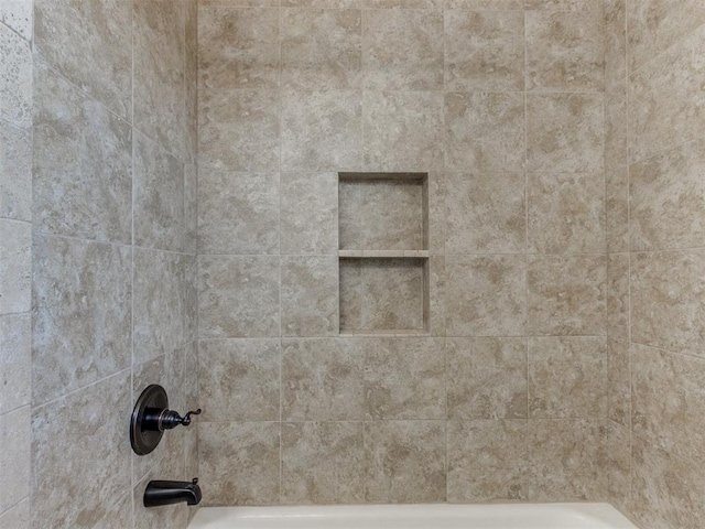 room details featuring tiled shower / bath