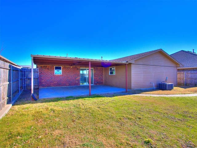 rear view of property with a lawn, central air condition unit, and a patio