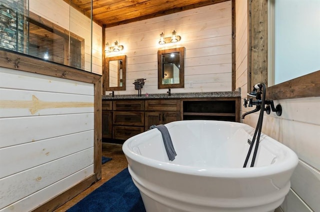 bathroom featuring a bathing tub, vanity, and wooden walls