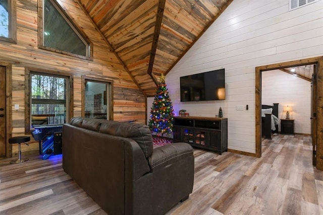 living room with light hardwood / wood-style floors, high vaulted ceiling, wood ceiling, and wood walls