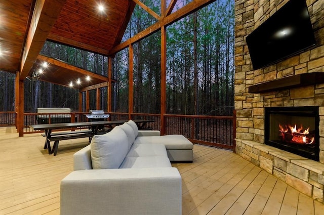 sunroom with vaulted ceiling, wood ceiling, and an outdoor stone fireplace