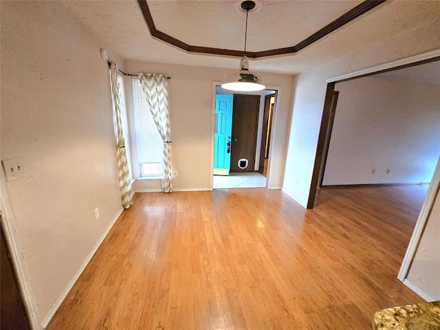 unfurnished dining area with light hardwood / wood-style floors, a raised ceiling, and a textured ceiling