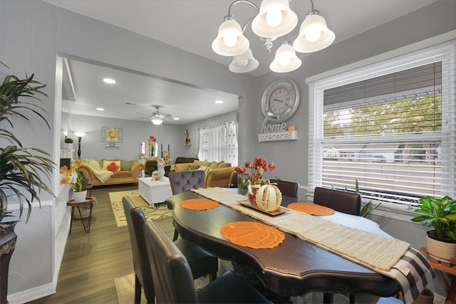 dining space with ceiling fan with notable chandelier and wood-type flooring