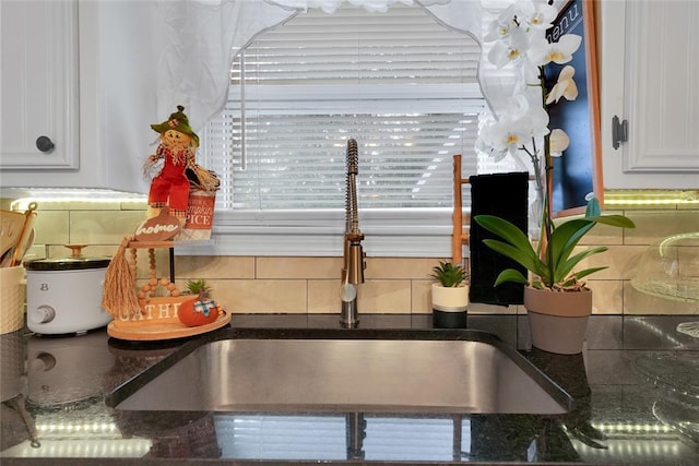 room details with sink, white cabinetry, and tasteful backsplash