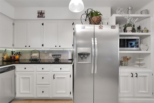 kitchen with stainless steel appliances, white cabinetry, backsplash, and crown molding