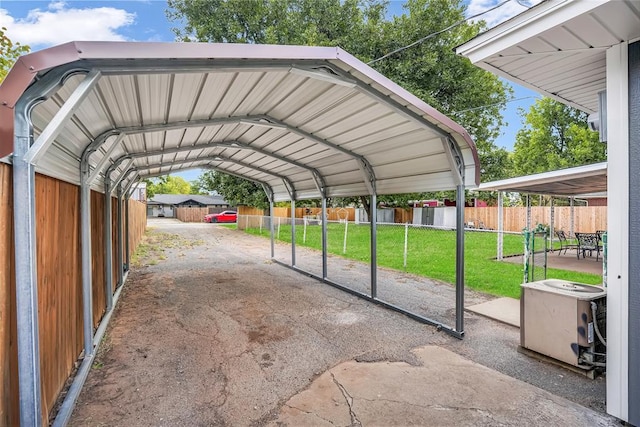 view of parking / parking lot featuring a carport and a lawn