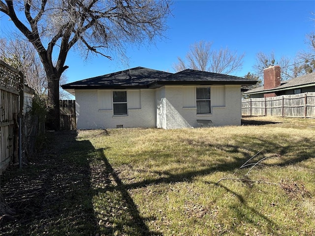 back of house with a yard, brick siding, crawl space, and a fenced backyard