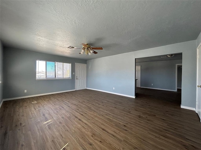 spare room with dark wood-style floors, ceiling fan, visible vents, and baseboards