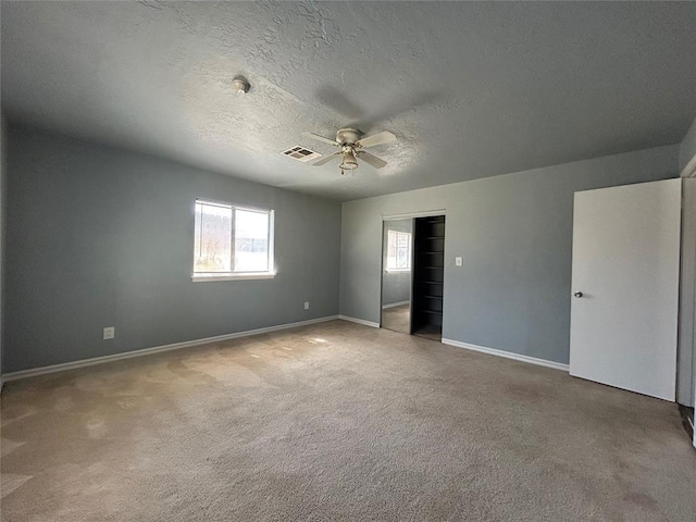 unfurnished bedroom with carpet floors, baseboards, visible vents, and a textured ceiling