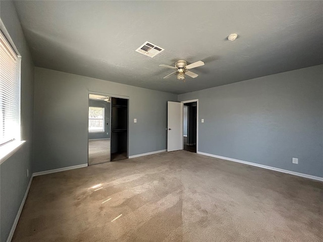 unfurnished bedroom featuring a ceiling fan, carpet, visible vents, and baseboards