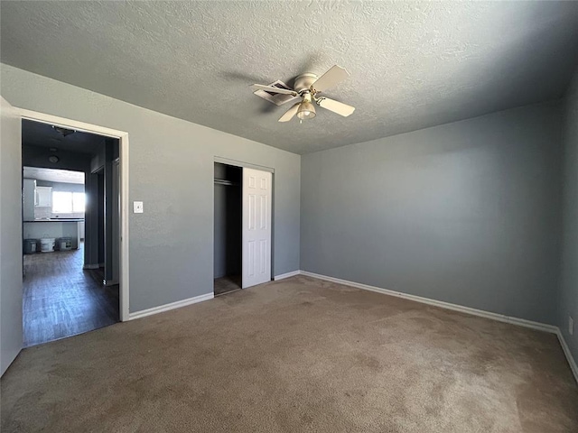 unfurnished bedroom featuring a textured ceiling, ceiling fan, a closet, and carpet