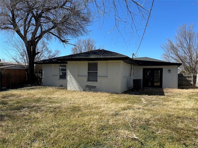 back of house featuring central air condition unit, fence, a lawn, and french doors