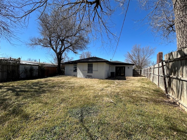 exterior space with a fenced backyard and a lawn