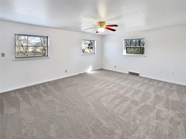 carpeted spare room with ceiling fan