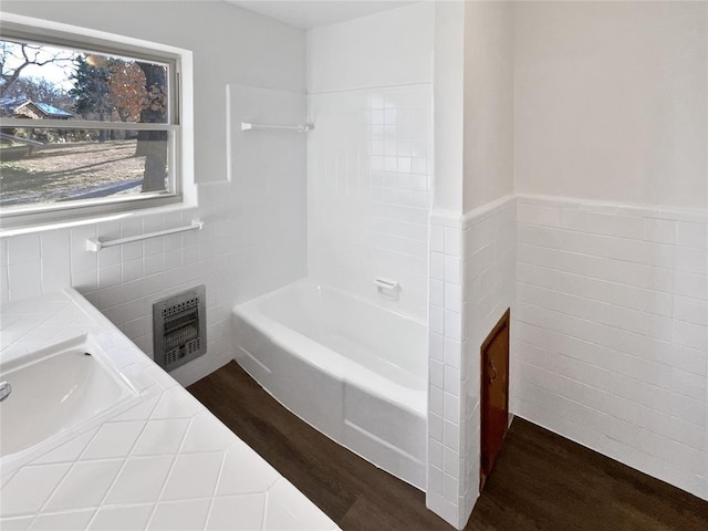 bathroom with a bathing tub, tile walls, wood-type flooring, and vanity