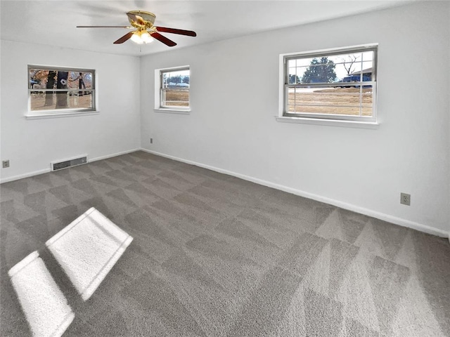 spare room with ceiling fan and dark carpet