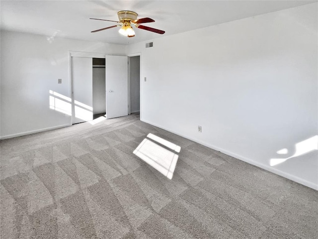 unfurnished bedroom with ceiling fan, carpet flooring, and a closet