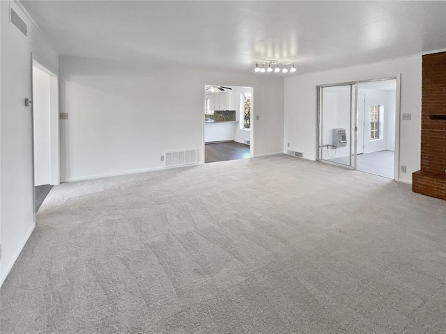 unfurnished living room featuring ceiling fan, a healthy amount of sunlight, and carpet floors