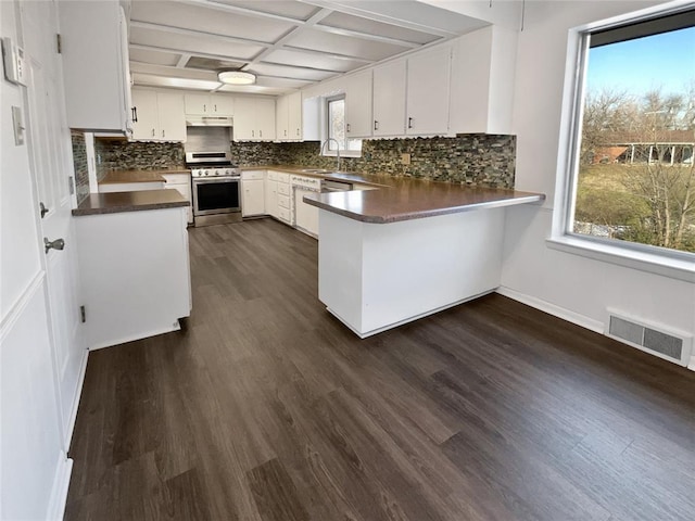 kitchen featuring white cabinets, sink, dark hardwood / wood-style floors, kitchen peninsula, and stainless steel range with gas stovetop