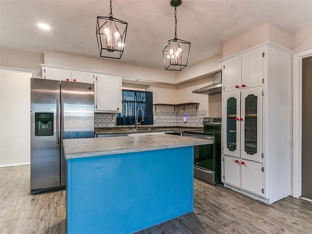 kitchen with hanging light fixtures, white cabinets, stainless steel appliances, and a kitchen island