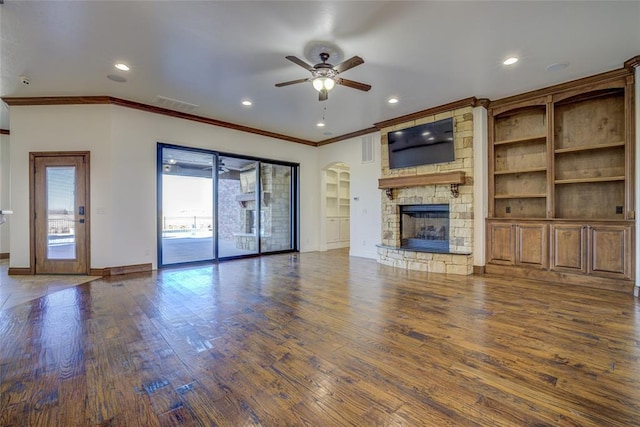 unfurnished living room with ceiling fan, dark hardwood / wood-style flooring, crown molding, and a fireplace