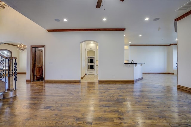 living room with crown molding, ceiling fan with notable chandelier, and hardwood / wood-style floors