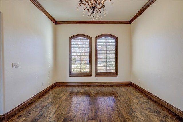 empty room featuring dark hardwood / wood-style flooring, an inviting chandelier, and ornamental molding