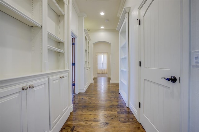 hallway with ornamental molding, dark hardwood / wood-style floors, and built in shelves