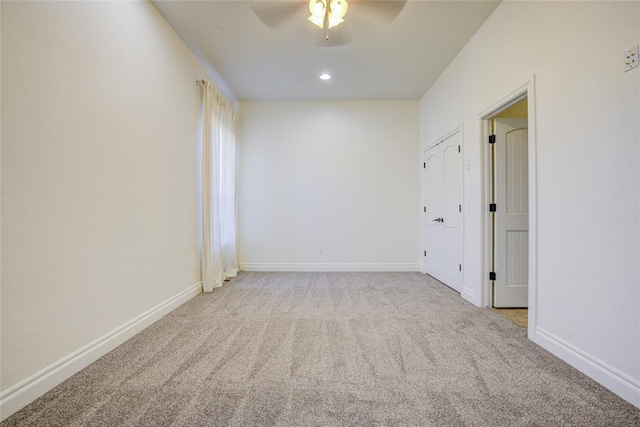 unfurnished room featuring ceiling fan and light colored carpet