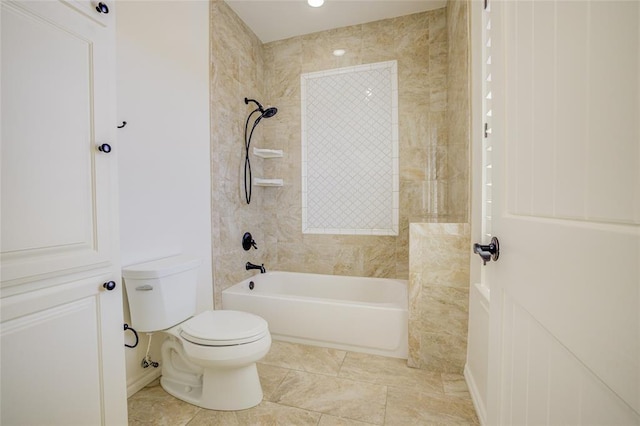 bathroom featuring toilet, tiled shower / bath, and tile patterned flooring