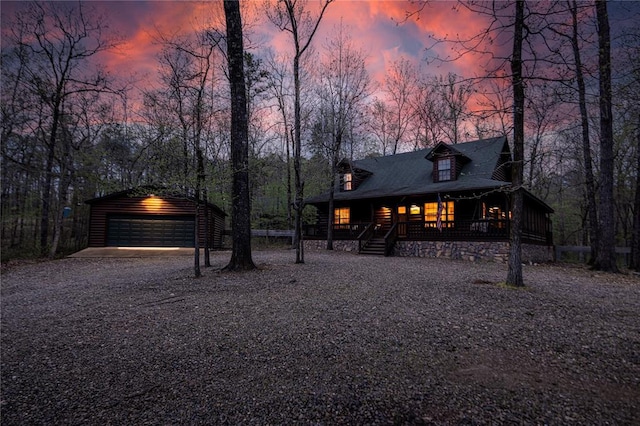 view of front of property with a garage, a porch, and an outdoor structure