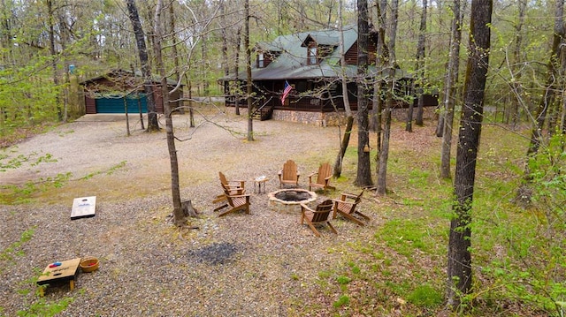 view of yard featuring a garage, an outbuilding, and a fire pit