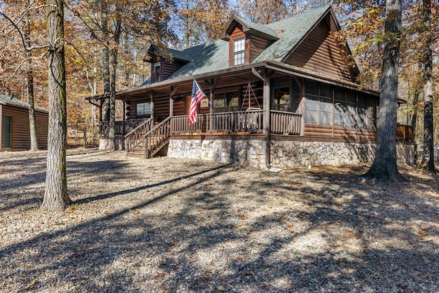 log cabin featuring covered porch