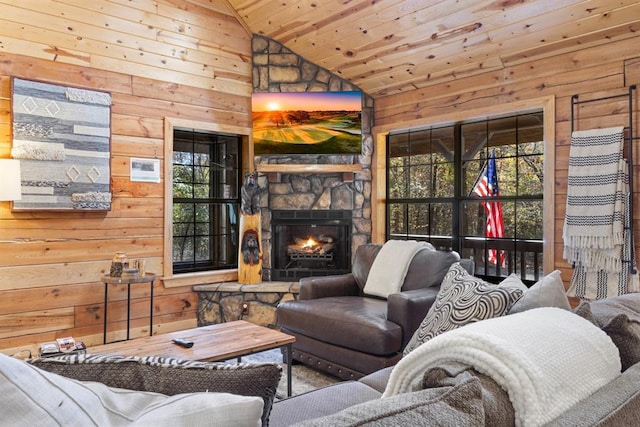 living room featuring vaulted ceiling, a stone fireplace, wooden walls, and wooden ceiling