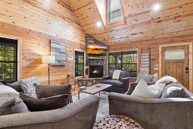 living room featuring a stone fireplace, wood ceiling, a skylight, high vaulted ceiling, and wood walls