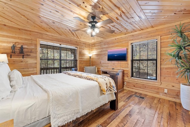 bedroom featuring wood-type flooring, wood walls, ceiling fan, and wood ceiling