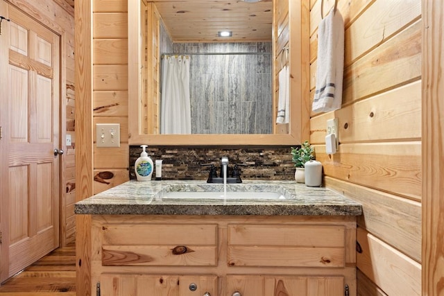 bathroom featuring wooden ceiling, vanity, and wooden walls