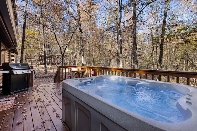 wooden deck with area for grilling and a hot tub