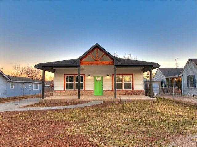 view of front facade featuring covered porch and a lawn