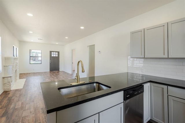 kitchen with decorative backsplash, gray cabinetry, stainless steel dishwasher, and sink