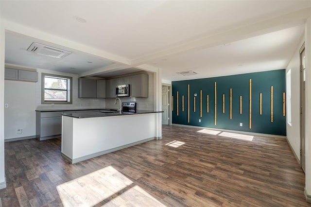 kitchen with dark wood-type flooring, decorative backsplash, and gray cabinetry