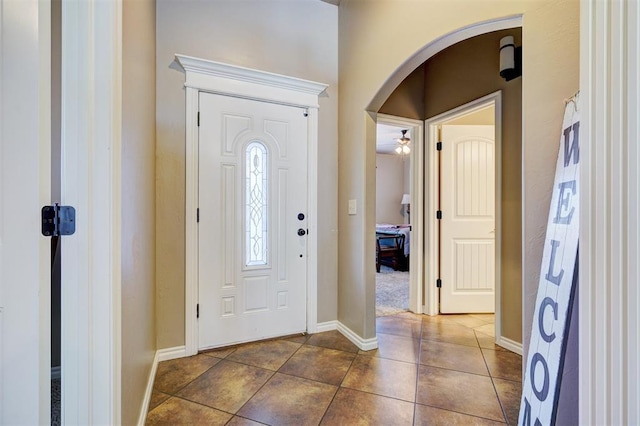 entryway with ceiling fan and dark tile patterned floors