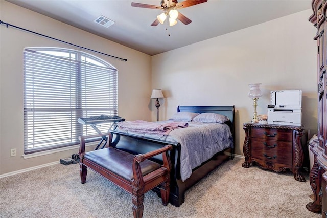 bedroom with ceiling fan, multiple windows, and light carpet