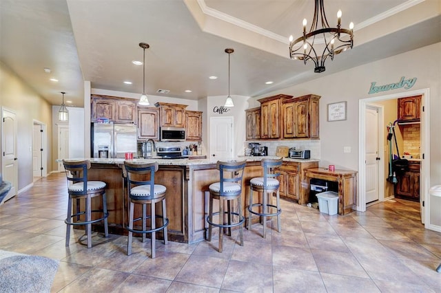 kitchen with decorative light fixtures, a large island with sink, appliances with stainless steel finishes, and a chandelier