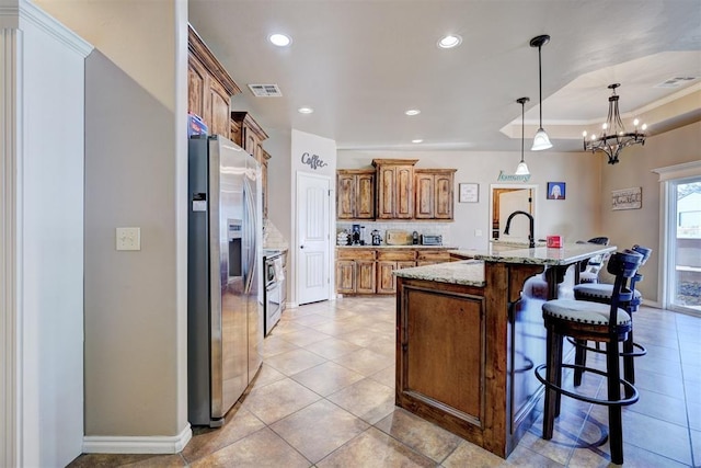 kitchen featuring an inviting chandelier, a kitchen bar, a large island, appliances with stainless steel finishes, and hanging light fixtures