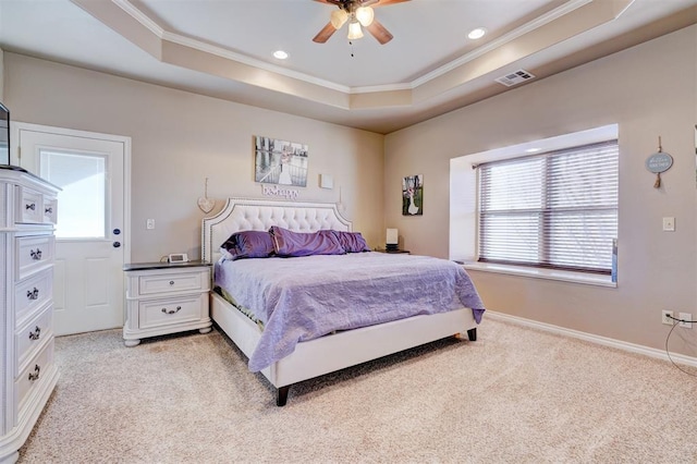 carpeted bedroom with ceiling fan, a tray ceiling, and ornamental molding