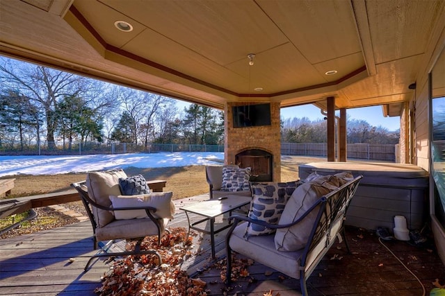 view of patio with an outdoor brick fireplace, a wooden deck, and a hot tub